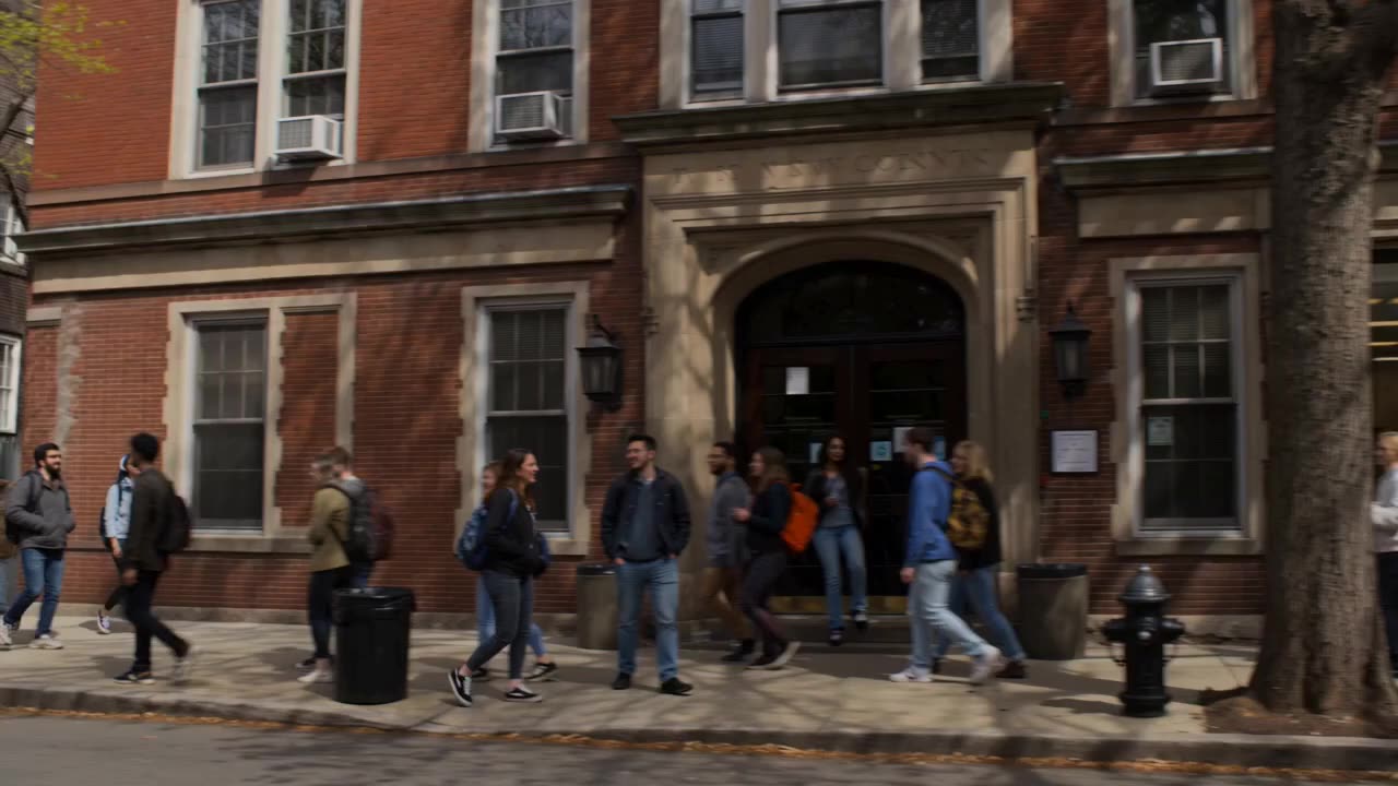 Outside a university building and a research laboratory entrance, with people coming and going.